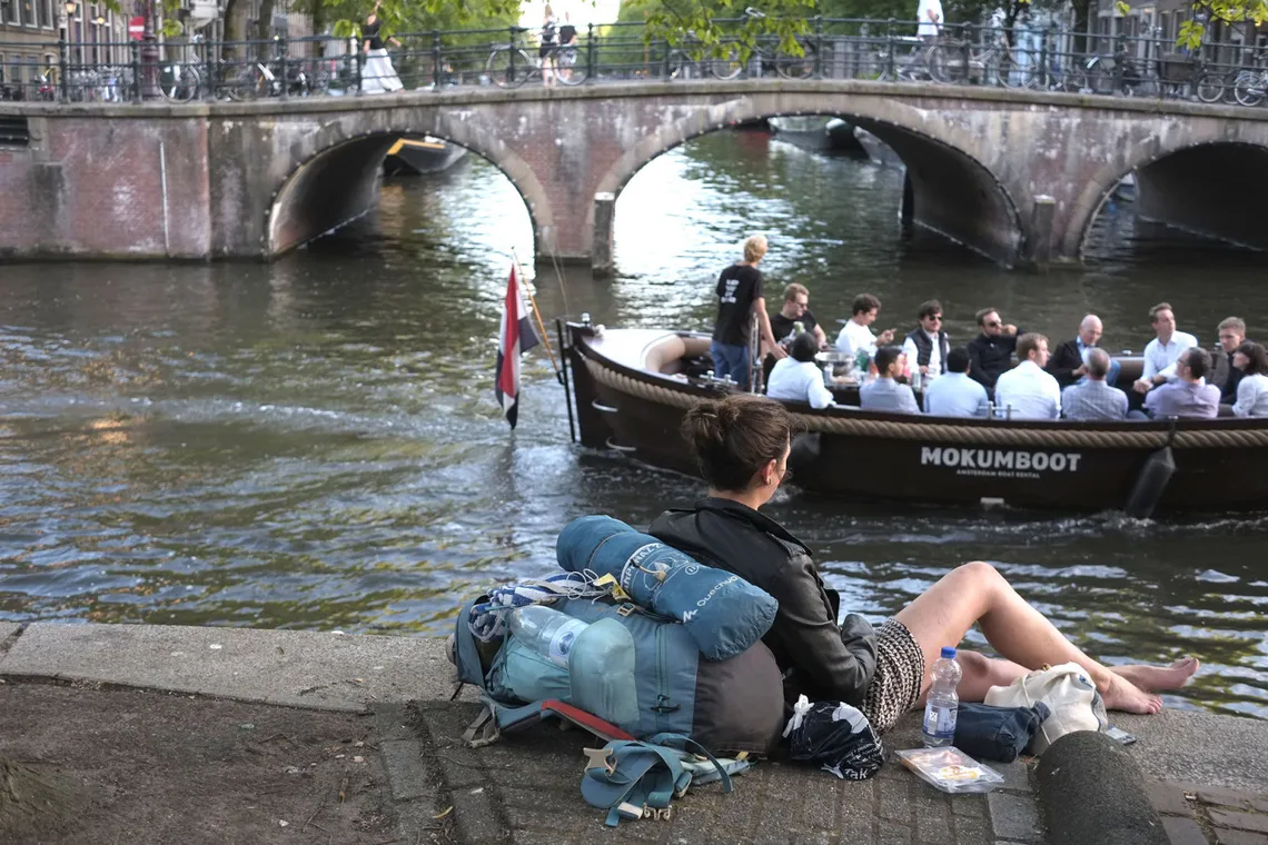 Canal bridge in Amsterdam with a boat passing underneath
