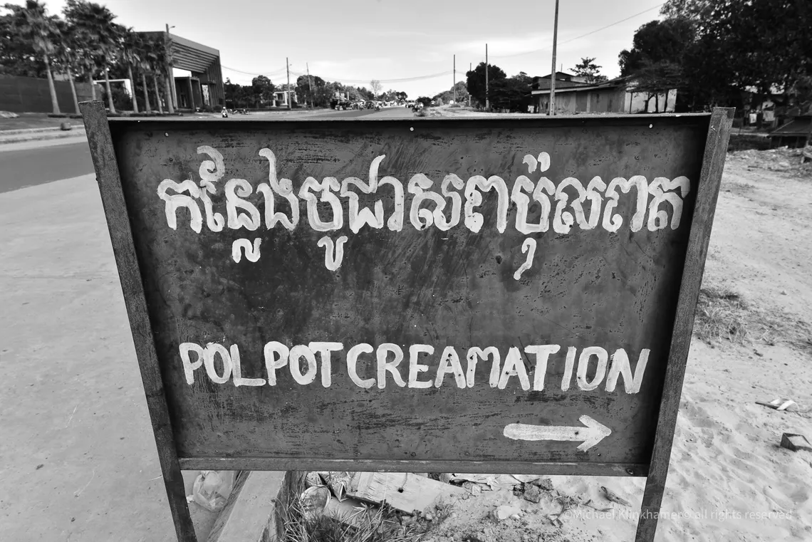 Hand painted sign pointing to the Pol Pot cremation site in Anlong Veng