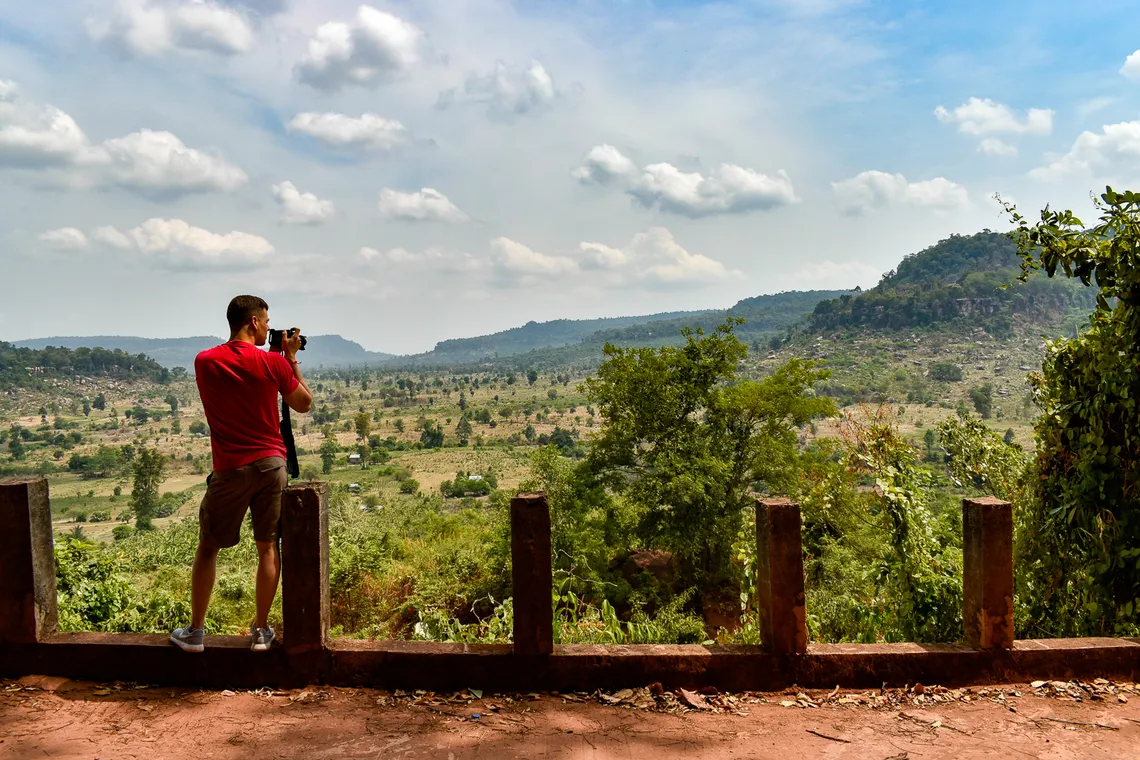 Photographer shooting from a viewpoint over the Cambodian highlands