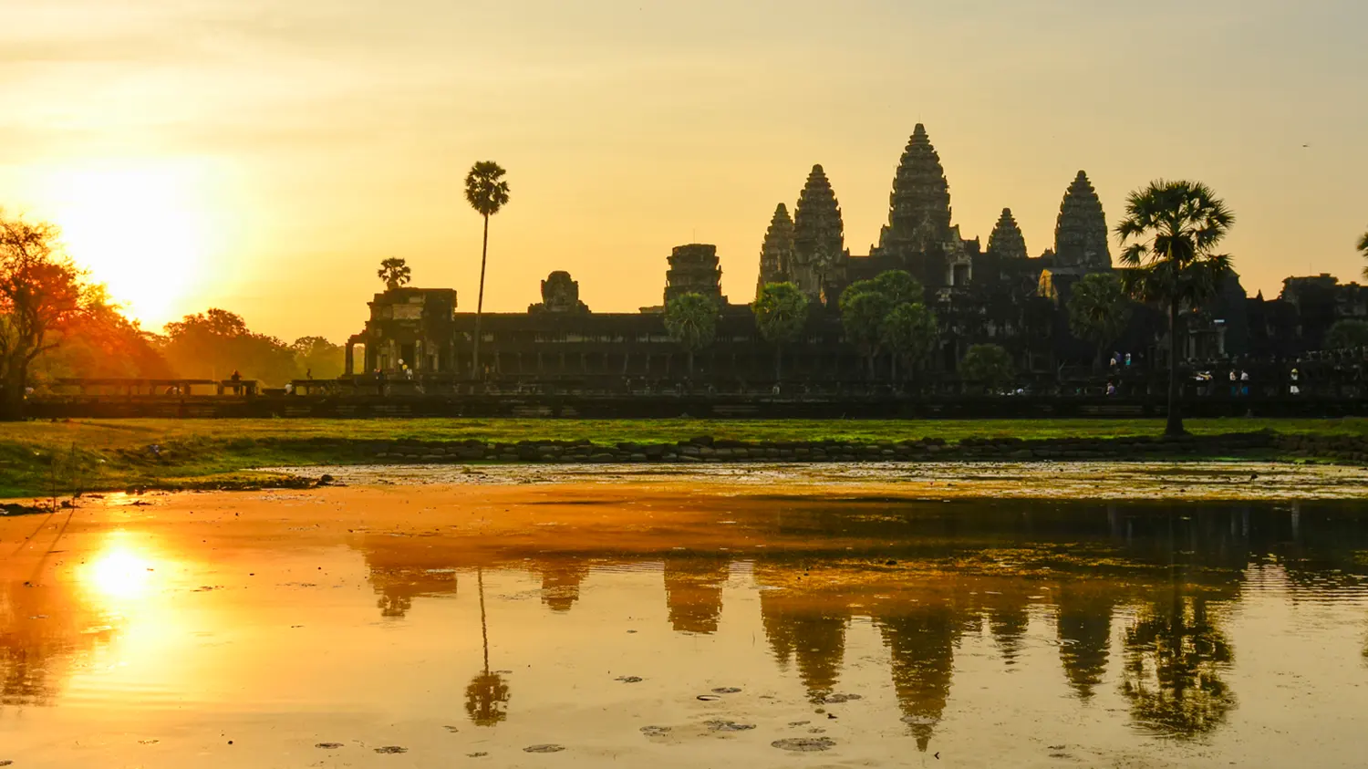 Sunrise over the towers of Angkor Wat reflected in the water