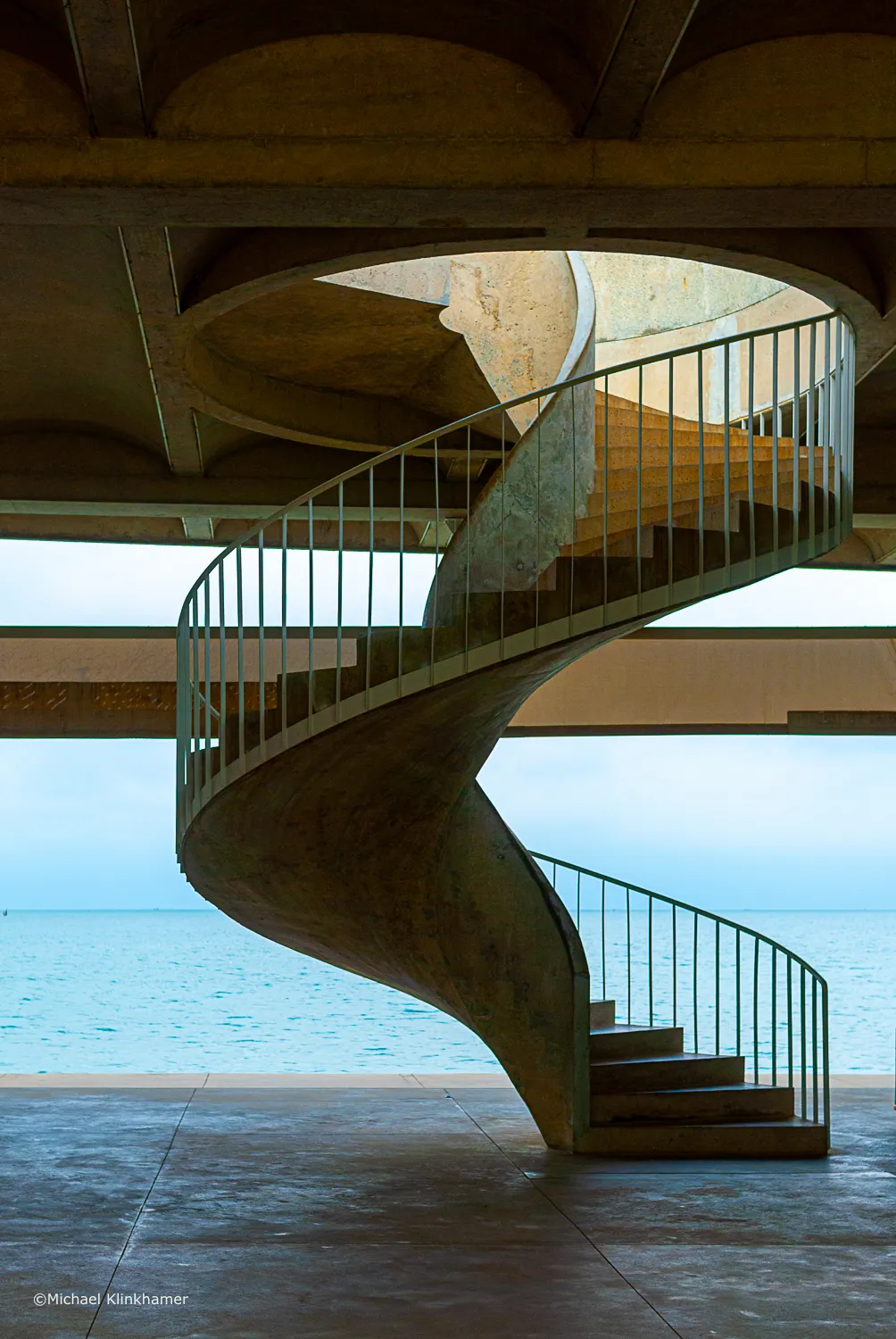 A curved modern staircase against a blue sky